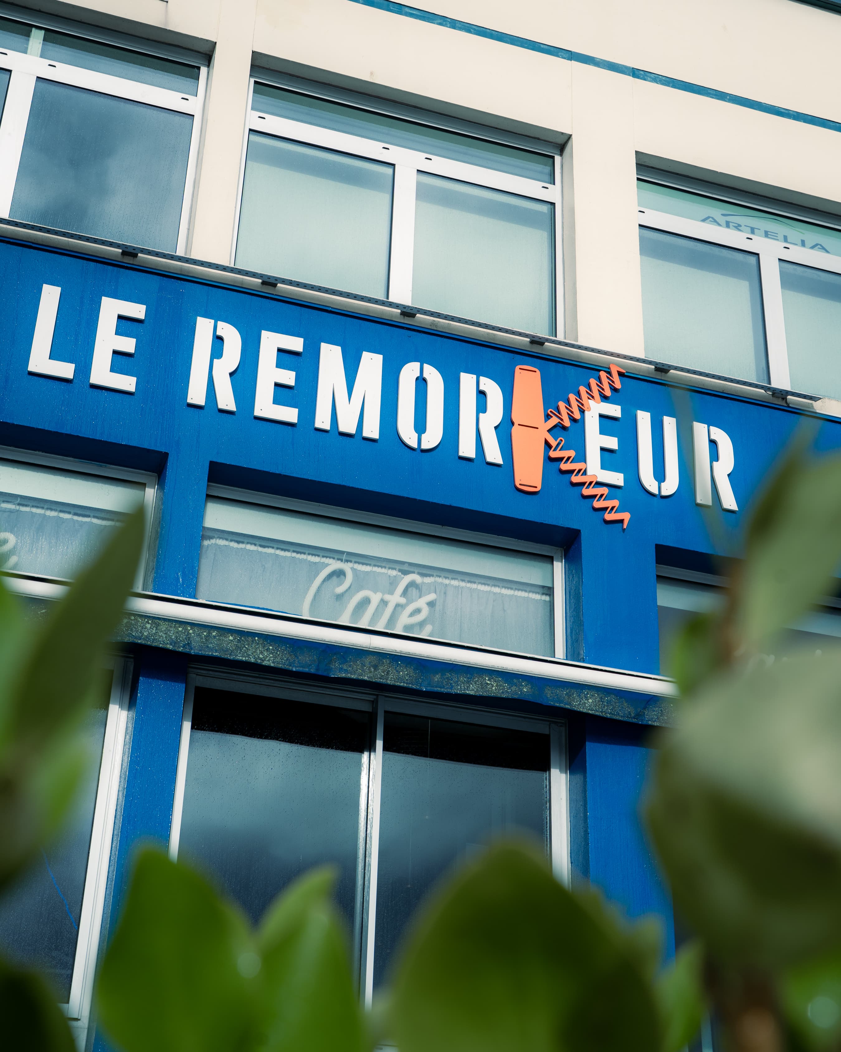 Enseigne Le RemorKeur — la lettre K stylisée en bouteille et décapsuleur